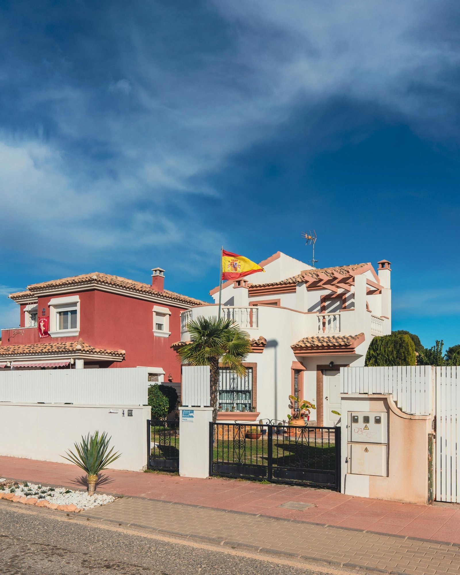 Charming Spanish houses with a flag under a bright blue sky, showcasing traditional architecture.